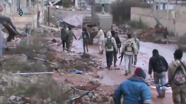 Syrian rebels walk through a field of flowers